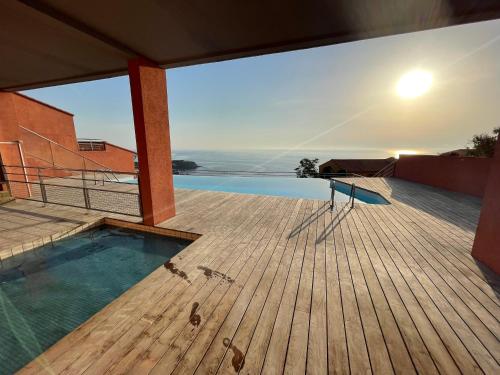 a house with a swimming pool on a wooden deck at Appartement avec vue exceptionnelle sur mer in Cerbère