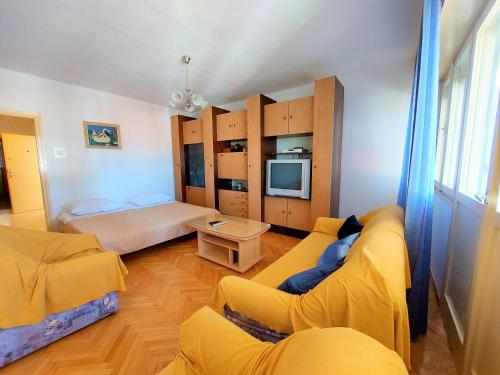 sala de estar con sofá, cama y TV en Apartman Ninsky en Primošten