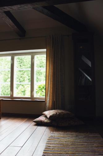 a bedroom with a large window and a rug at Mõisa Ait Katusekorter in Võru