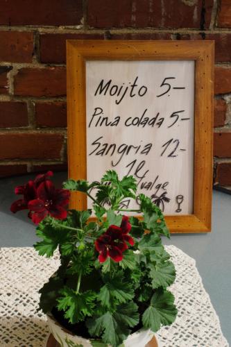 a sign and a plant on a table with flowers at Mõisa Ait Katusekorter in Võru