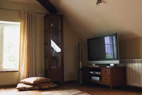 una sala de estar con TV de pantalla plana en una cómoda en Mõisa Ait Katusekorter, en Võru