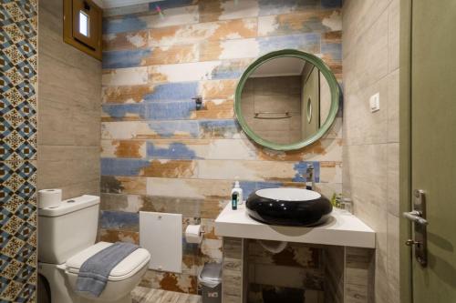 a bathroom with a white toilet and a mirror at Jacksons sea view living in Kos