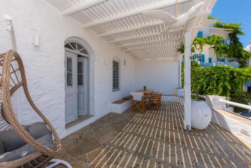 a patio with a white building with a white pergola at NIREAS STONEHOUSE IN APOLLONIA SIFNOS in Sifnos