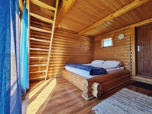 pokój z łóżkiem w drewnianym domku w obiekcie Vanamõisa Caravan Park w mieście Saue