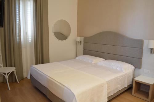 a bedroom with a large white bed and a mirror at Agriturismo Li Damiani in Otranto