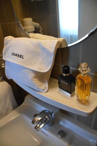 - un lavabo avec une bouteille de savon et un miroir dans l'établissement Logis Hôtel Restaurant de France, à Saint-Geniez-dʼOlt