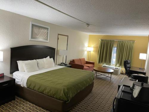 a hotel room with a bed and a chair at Quality Inn in Vincennes