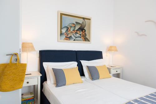 sypialnia z łóżkiem z żółtymi i białymi poduszkami w obiekcie NEFELI'S GUESTHOUSE IN PLATYS GIALOS SIFNOS w mieście Platis Gialos Sifnos