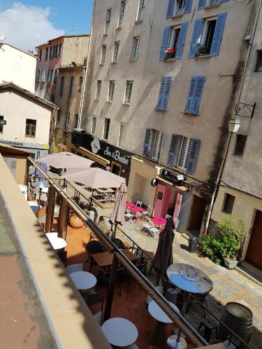 un patio extérieur avec des tables, des parasols et des bâtiments dans l'établissement AJACCIO CENTRE VIEILLE VILLE IMPÉRIALE TT CONFORT TTES COMMODITÉS 3 a 4 PERs CATHÉDRALE A 300M MER PORT MARCHE LOCAL PLAGES, à Ajaccio