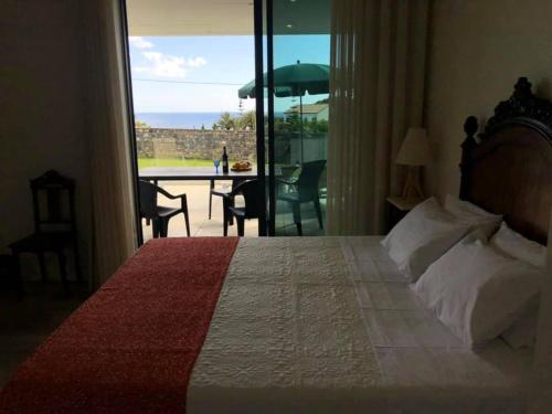 a bedroom with a bed and a view of the ocean at Jubileu 74 in Caloura