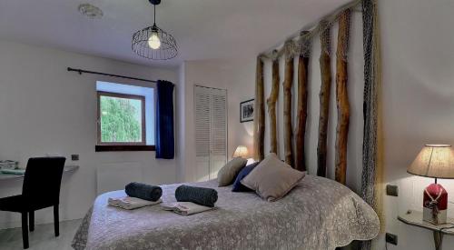 a bedroom with a bed with two pillows on it at Chambres d'Hôtes Les Fleurettes en Baie Du Mont Saint Michel in Saint-Marcan