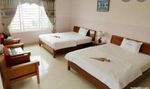 um quarto de hotel com duas camas e uma janela em NHÀ NGHỈ MINH NHI em Da Nang