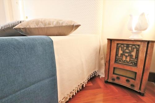 a bed with a pillow on it next to a table at Relais Delle Rose in Lecce
