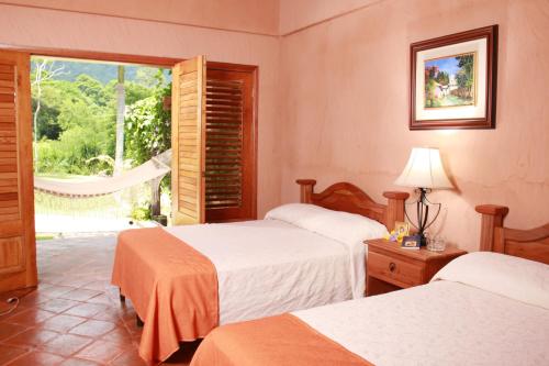 Habitación de hotel con 2 camas y ventana en La Villa de Soledad, en La Ceiba