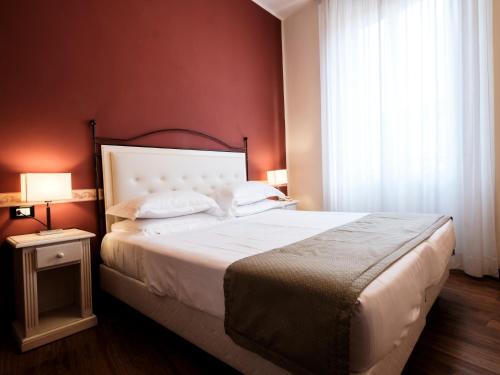 a bedroom with a large bed with red walls at Hotel Accademia in Bologna