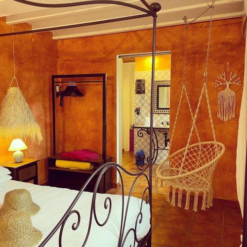 a bedroom with a swinging bed and a mirror at chambres d hotes Le Mas Julien piscine chauffée adult only in Orange