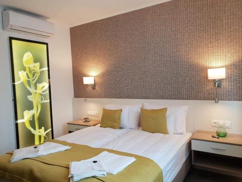 um quarto de hotel com uma cama e duas mesas de cabeceira em Villa Heuréka em Gárdony