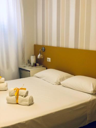 a bedroom with two beds with towels on the bed at Hotel Villa Rosa in Porto Azzurro