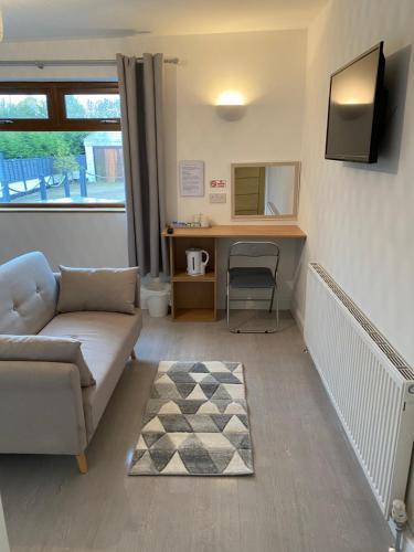 a living room with a couch and a desk at The Bungalow in Leeds