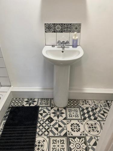 a bathroom with a sink and a tile floor at The Bungalow in Leeds