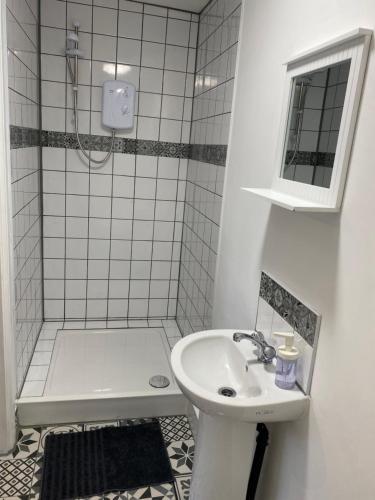 a white bathroom with a sink and a shower at The Bungalow in Leeds