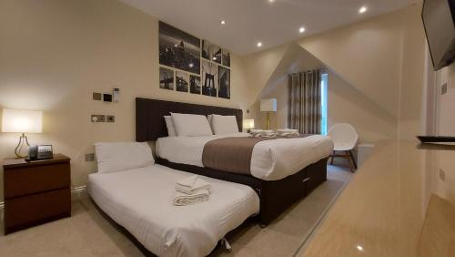 a bedroom with two beds with white pillows at London Star Hotel in London