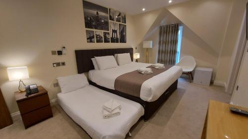 a hotel room with two beds and a desk at London Star Hotel in London
