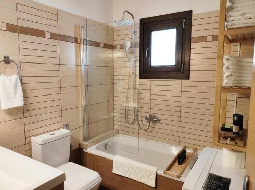 a bathroom with a tub and a toilet and a sink at To Spiti - Pelion House in Kala Nera