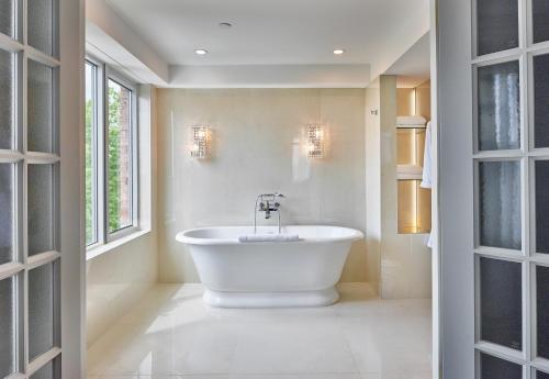 a bathroom with a large white tub in a room at Chateau Vaudreuil in Vaudreuil-Dorion