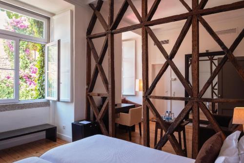 York House Lisboa Hotel في لشبونة: غرفة نوم مع شرفة خشبية كبيرة