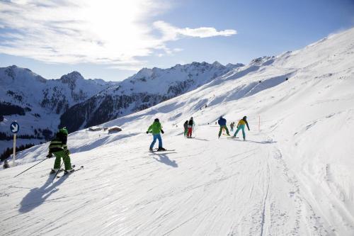 a group of people skiing down a snow covered slope at Schlossbergblick in Radfeld