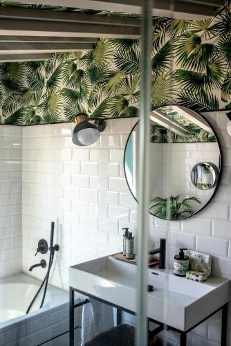 a bathroom with a sink and a mirror and a tub at Apartamentos Boutique Fuente Real in Comillas