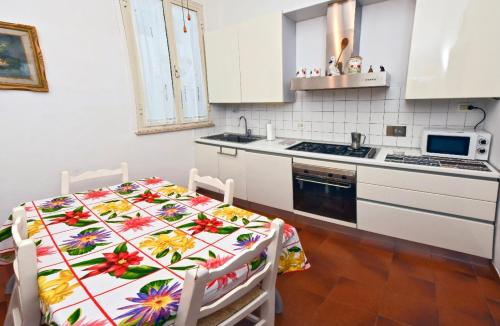 Appartamento Borgo 98 Guest House في ليفورنو: مطبخ مع طاولة عليها قطعة قماش من الزهور