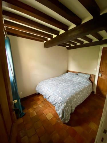 une chambre avec un lit dans une pièce avec des plafonds en bois dans l'établissement Le nid normand, à Honfleur
