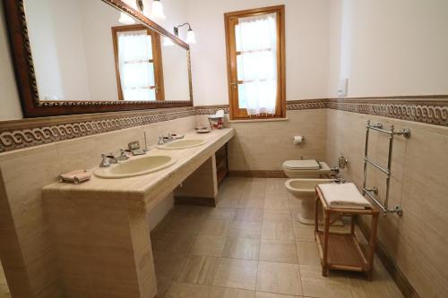a bathroom with two sinks and two toilets at Relais Delle Rose in Lecce