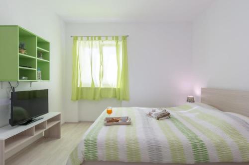 a bedroom with a bed and a flat screen tv at Modern room old Town - Zadar in Zadar