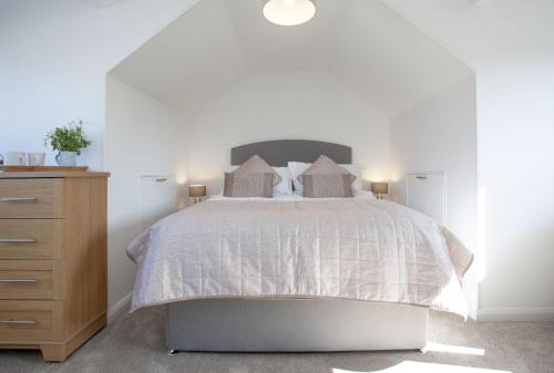 a bedroom with a bed and a wooden dresser at Bridge Apartment in Perranporth