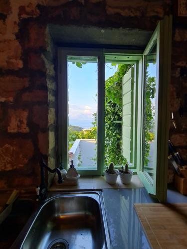 a kitchen sink with a view of a window at Peacefull and Romantic Hillside House in Jelsa