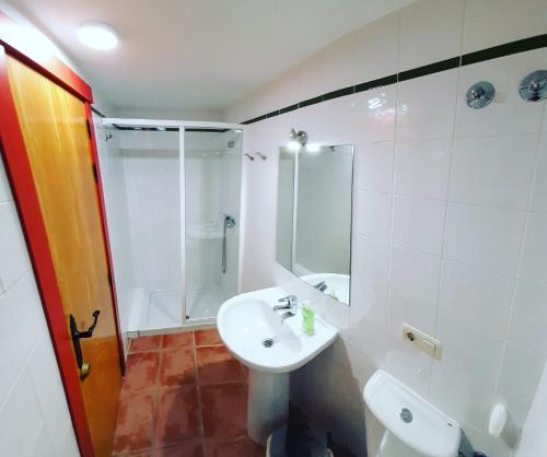 a white bathroom with a sink and a shower at Albergue El Pajar de Agés - Exclusivo para peregrinos - Exclusive for pilgrims in Agés