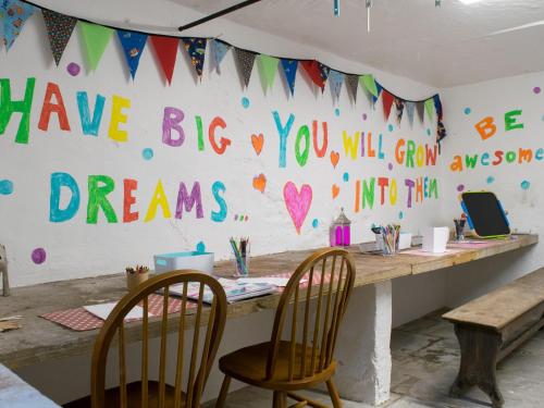 a table with two chairs and a wall with messages at Micklethorn at Broughton Sanctuary in Skipton