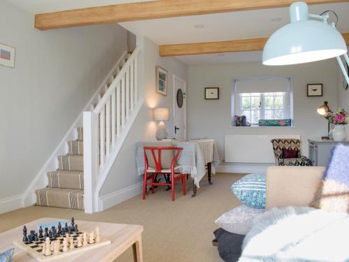 a living room with a table and a staircase at Micklethorn at Broughton Sanctuary in Skipton