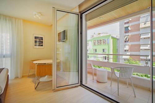 a room with a balcony with a table and chairs at The Rooms Serviced Apartments Tirana in Tirana