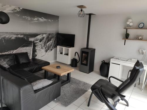 a living room with a couch and a tv at SeaSide4you in De Haan