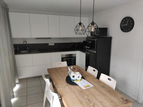 a kitchen with a wooden table and a black refrigerator at SeaSide4you in De Haan