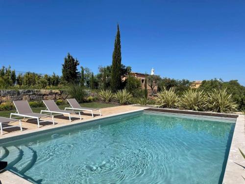 una piscina con 2 sillas y una piscina en Luxury Villa, Ocean View, Private Heated Pool en Ferragudo