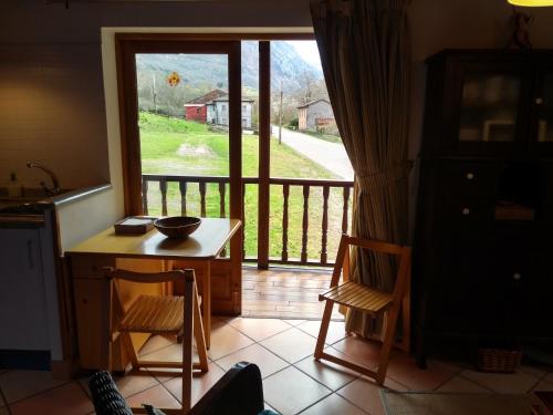 una cocina con mesa y sillas y una puerta corredera de cristal en Apartamento Aguas del Sella, en Precendi