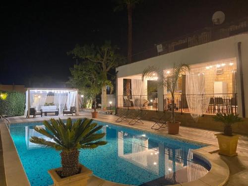 een zwembad voor een huis 's nachts bij VILLA MARIANNA CON PISCINA PRIVATA ampi spazi esterni e WIFI FREE in Trabia