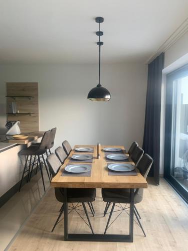 a dining room table with chairs and aendant light at SD-Apartment in Spielberg