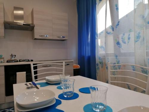 eine Küche mit einem Tisch mit Tellern und Gläsern darauf in der Unterkunft Momaliar House in Campofelice di Roccella