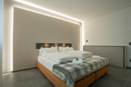 a bedroom with a large bed with white pillows at Ca' de L'Olif - Holiday Clima Apartments in Dro